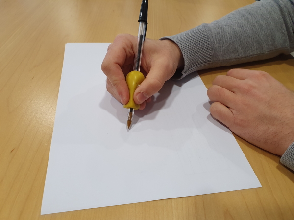 main tenant un stylo avec un manchon pour élargir le diamètre d'un stylo