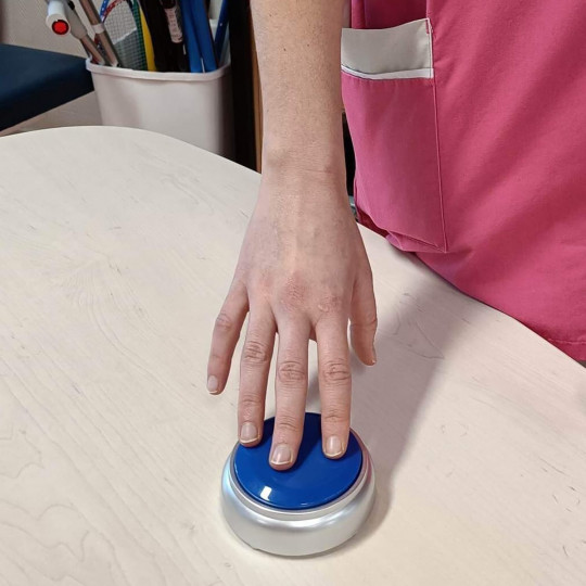 Personne qui appuie sur l'interrupteur de 9 centimètres de diamètre pour avoir l'heure et la date.