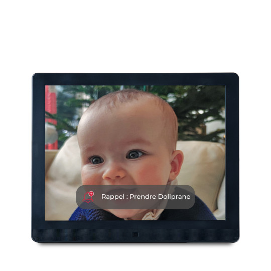 cadre photo sur fond fond présentant la photo d'un portrait de bébé. Par dessus s'affiche un message pour illustrer l’affichage d'un rappel sur l'écran: Prendre Doliprane.