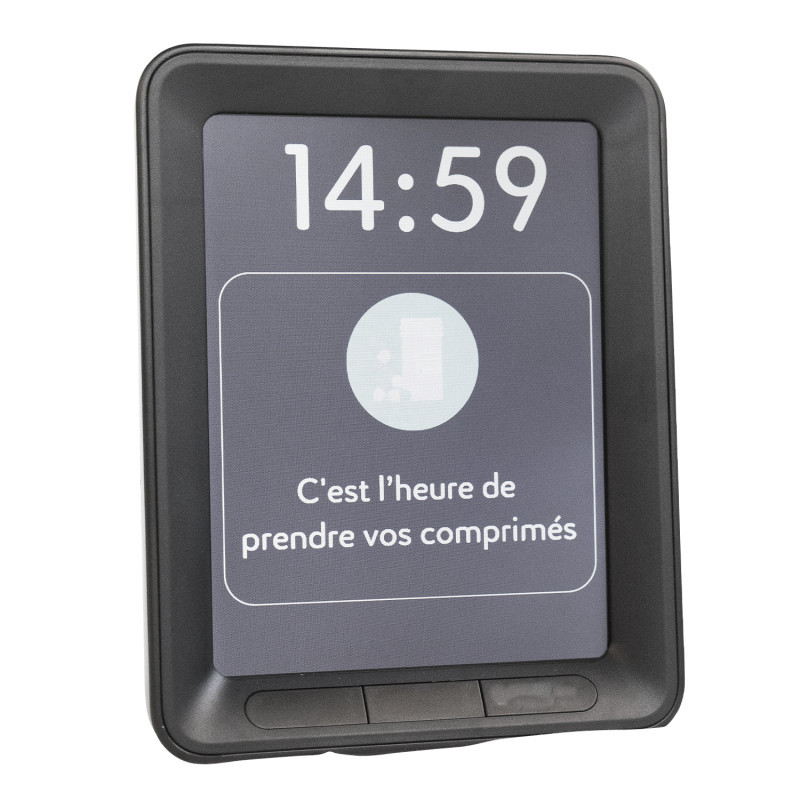 Horloge calendrier noire et rectangulaire présentant un écran affichant l'heure et en dessous un rappel indiquant : c'est l'heure de prendre vos comprimés.