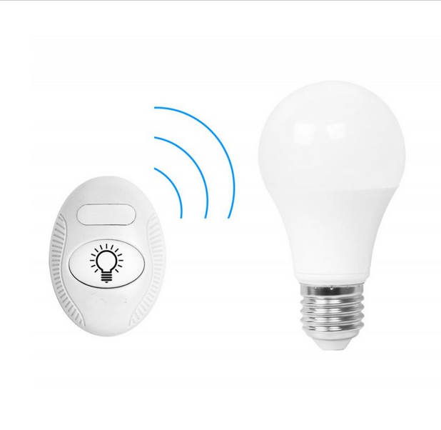 Sur un fond blanc, on voit une ampoule blanche à culot métallique posée à droite, et à gauche, un petit interrupteur ovale sans fil. L’interrupteur est blanc, avec le dessin d’une ampoule au centre et des ondes bleues stylisées reliant les deux objets, suggérant une connexion sans fil.