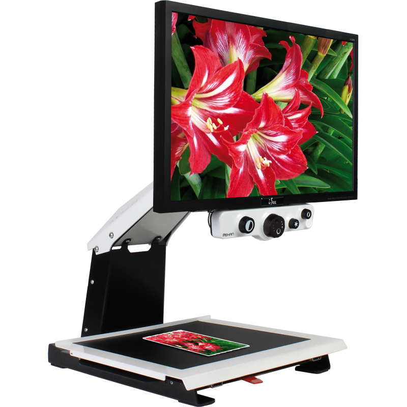 Télé-agrandisseur sur un fond blanc. Il y a une carte postale de fleurs qui est posée sous l'écran. On la voit à l'écran avec un grossissement d'une partie de l'image.